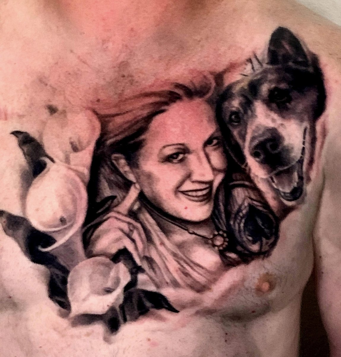 Black and gray realism chest portrait tattoo of a woman with a Bull Terrier dog surrounded by calla lilies by Zack Ross, custom tattoo artist Kyle TX serving Austin and Dallas