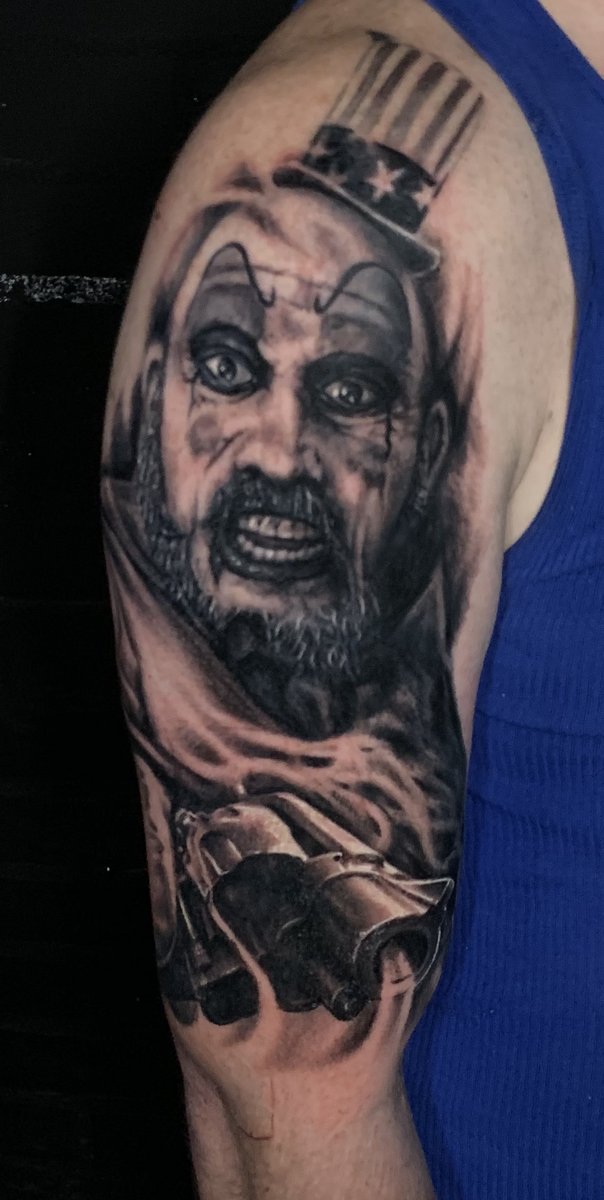 Black and gray realism horror portrait half sleeve tattoo of Captain Spaulding clown character with gun by Zack Ross, Kyle TX tattoo artist serving Austin Texas