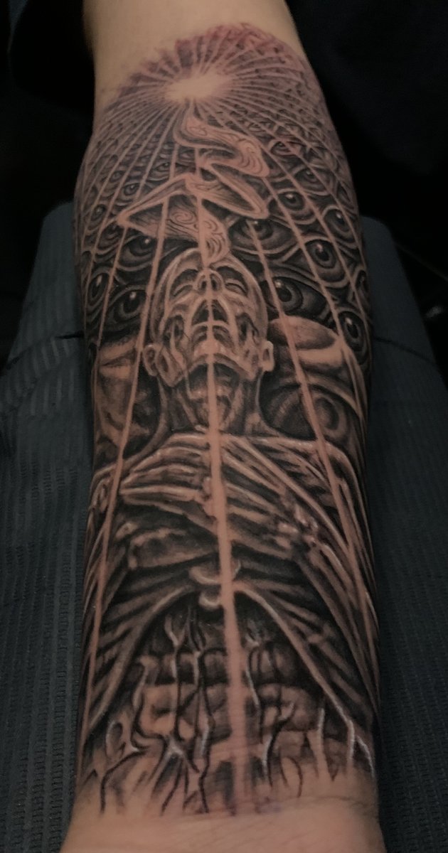 Healed black and gray forearm tattoo of surreal spiritual anatomical figure with grid of eyes and radiant light, illustrative realism by Zack Ross, tattoo artist Kyle TX near Austin